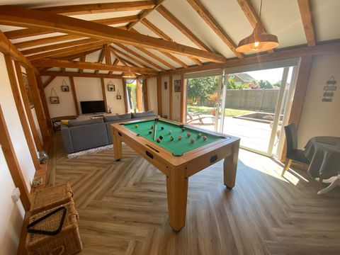 Finished games room interior with exposed oak trusses, pool table and glazing to the garden